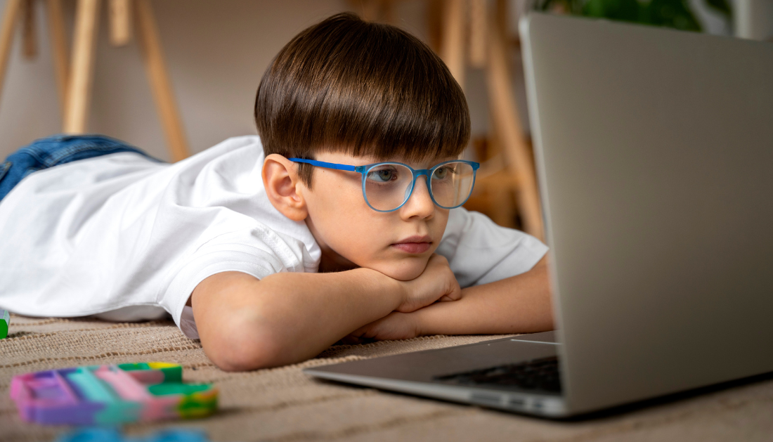 A child using a computer with a worried expression, representing the link between screen time and myopia.